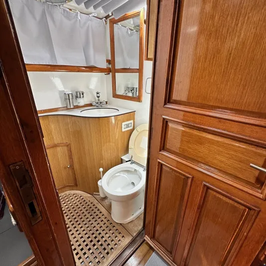  Yacht Photos Pics Wood-paneled bathroom on 1994 Viking Marin Caicco yacht, featuring toilet, sink, and mirror.