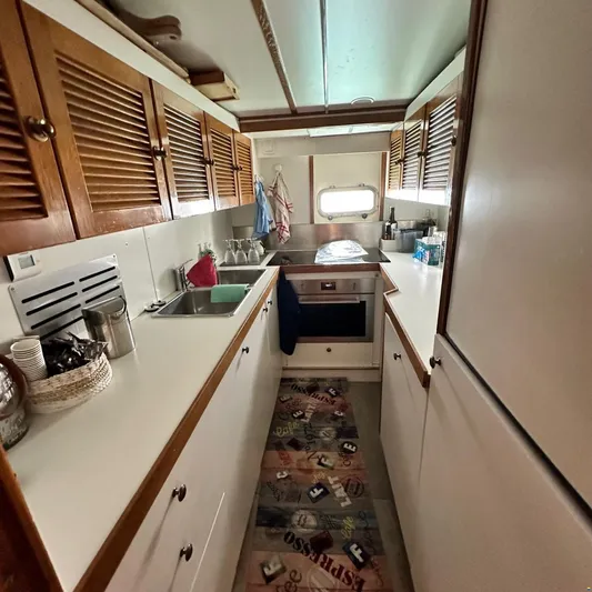  Yacht Photos Pics Compact kitchen in 1994 Viking Marin Caicco boat with wooden cabinets and modern appliances.