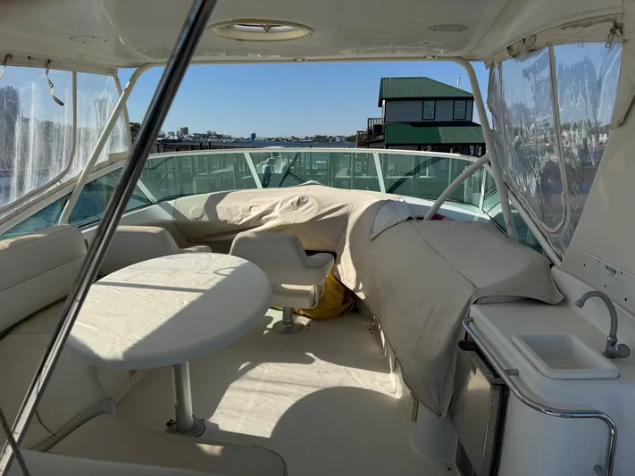  Yacht Photos Pics 2007 Carver 46 Voyager yacht interior with seating and table, docked near waterfront homes.