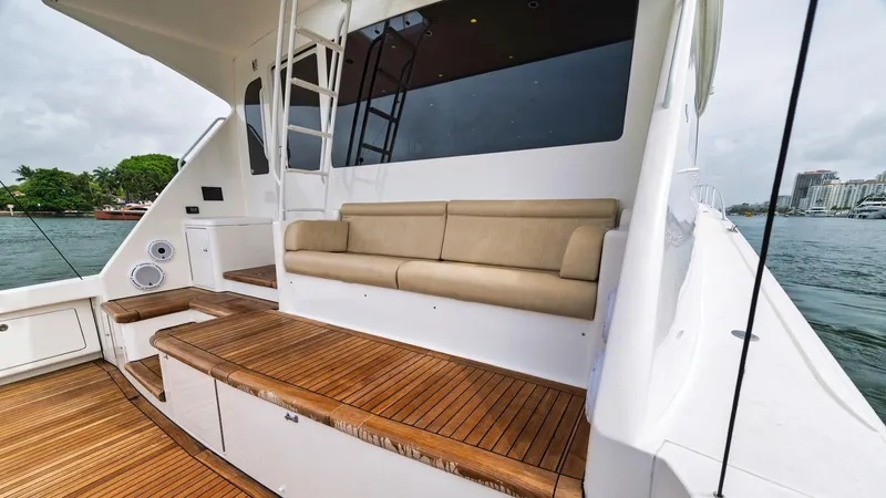 Nailed It Yacht Photos Pics Luxury Viking 74EB yacht deck with seating, wood flooring, and ocean view.