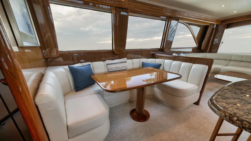 Nailed It Yacht Photos Pics Luxurious interior of 2008 Viking 74EB yacht with elegant seating and wooden table.