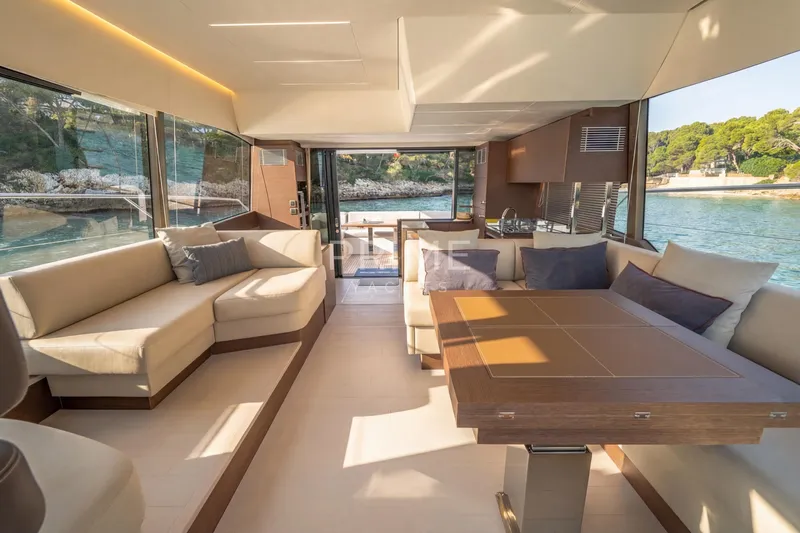 One Step Closer Yacht Photos Pics Luxurious interior of 2024 Prestige 590 yacht with elegant seating and scenic ocean views.