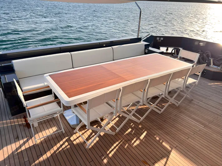 Aquila Yacht Photos Pics Luxury yacht deck with dining table, chairs, and ocean view; Mengi Yay 36M Pennon, 2015 model.