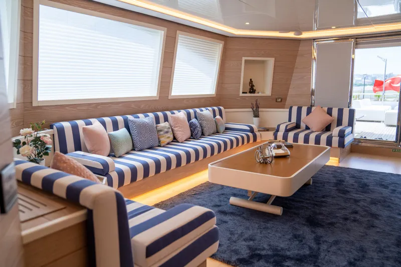 Aquila Yacht Photos Pics Luxurious yacht interior with striped seating, modern decor, and a sleek coffee table. Mengi Yay 36M Pennon, 2015.