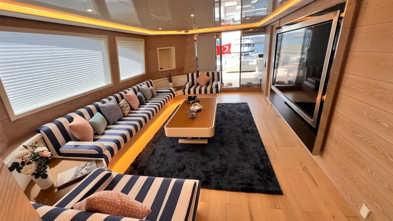 Aquila Yacht Photos Pics Luxurious yacht interior with striped seating, large TV, and elegant decor on Mengi Yay 36M Pennon.