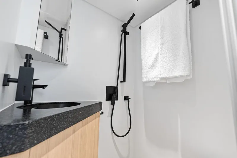 Fellowship II Yacht Photos Pics Modern bathroom in 2023 Wajer 77 yacht with sleek black fixtures and white towel.
