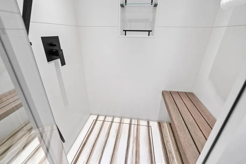 Fellowship II Yacht Photos Pics Luxurious shower area in 2023 Wajer 77 yacht with wooden bench and modern fixtures.