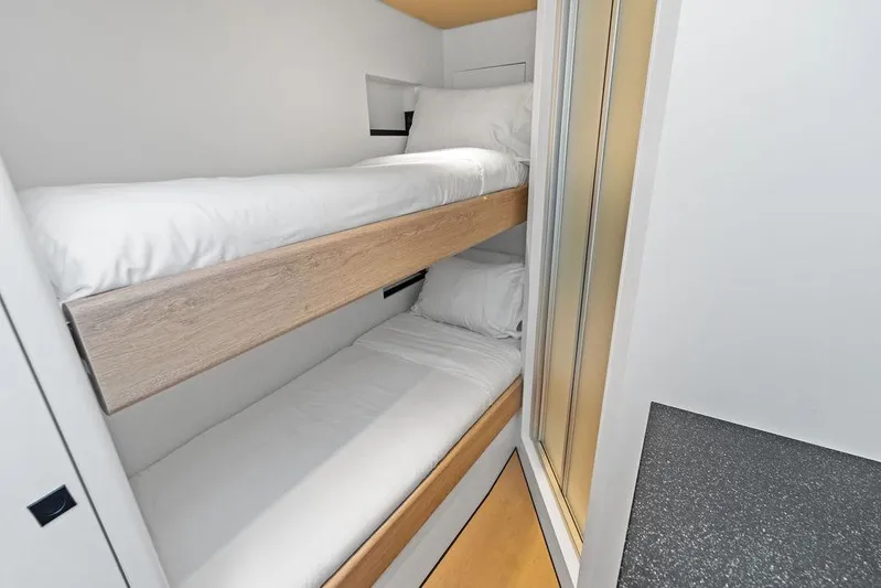 Fellowship II Yacht Photos Pics Bunk beds in a 2023 Wajer 77 yacht cabin, featuring modern design and cozy bedding.