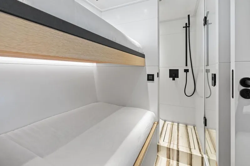 Fellowship II Yacht Photos Pics Luxurious interior of 2023 Wajer 77 yacht featuring modern bunk beds and sleek shower area.