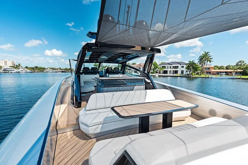 Fellowship II Yacht Photos Pics Luxurious 2023 Wajer 77 yacht with elegant seating, cruising on a sunny waterfront.