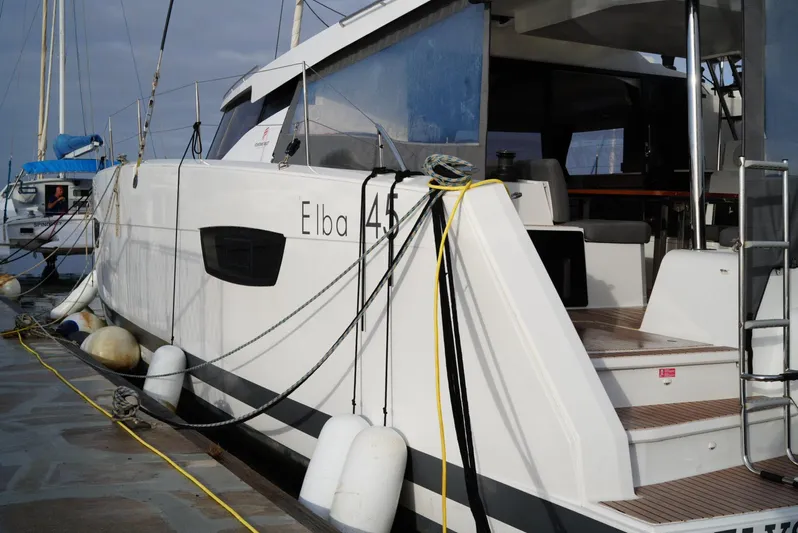 Elysium 1 Yacht Photos Pics 2022 Fountaine Pajot Elba Quatour catamaran docked, showcasing sleek design and modern features.
