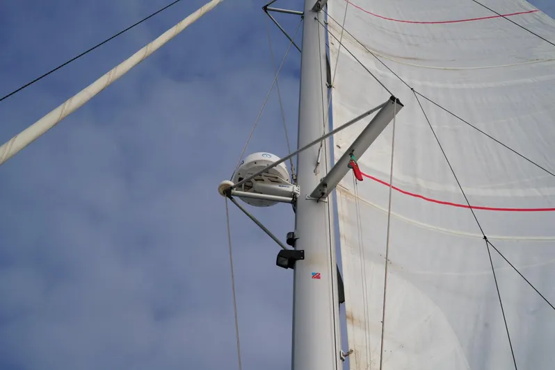 Elysium 1 Yacht Photos Pics Sail and mast of 2022 Fountaine Pajot Elba Quatour against a cloudy sky.