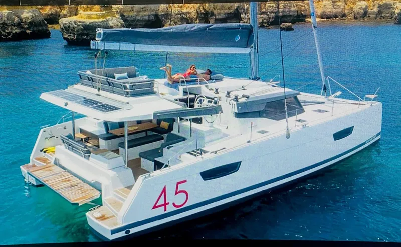 Elysium 1 Yacht Photos Pics 2022 Fountaine Pajot Elba Quatour catamaran sailing in clear blue waters.