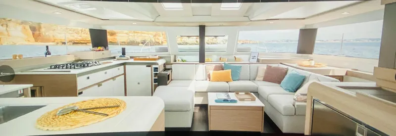 Elysium 1 Yacht Photos Pics Luxurious interior of 2022 Fountaine Pajot Elba Quatour catamaran with modern kitchen and seating area.