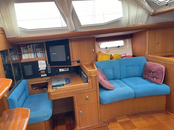 Dream Again II Yacht Photos Pics Interior of 2003 Oyster 53 yacht with blue seating and wooden cabinetry.
