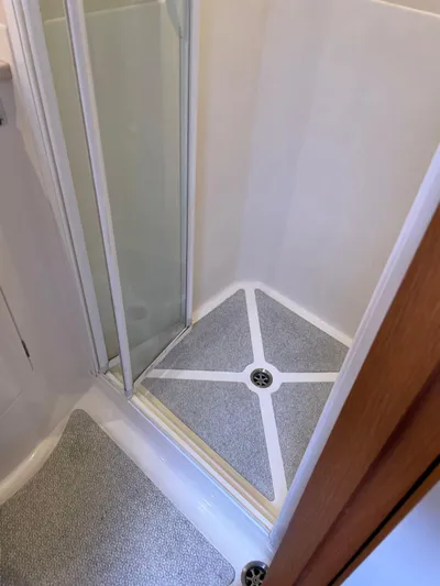 Dream Again II Yacht Photos Pics Shower area in 2003 Oyster 53 yacht with sliding glass door and non-slip flooring.