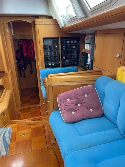 Dream Again II Yacht Photos Pics Interior of 2003 Oyster 53 yacht with blue seating and wooden cabinetry.