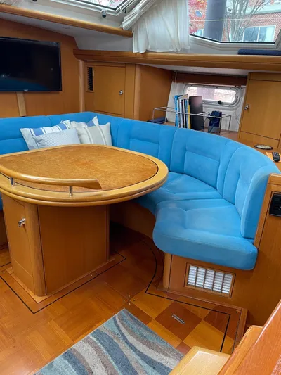 Dream Again II Yacht Photos Pics Interior of 2003 Oyster 53 yacht with blue seating and wooden table.