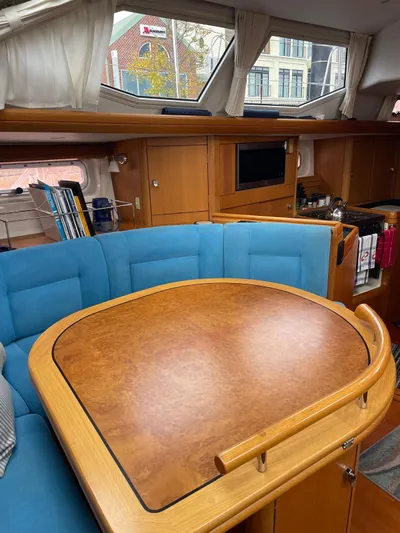 Dream Again II Yacht Photos Pics Interior of 2003 Oyster 53 yacht with wooden table and blue seating.