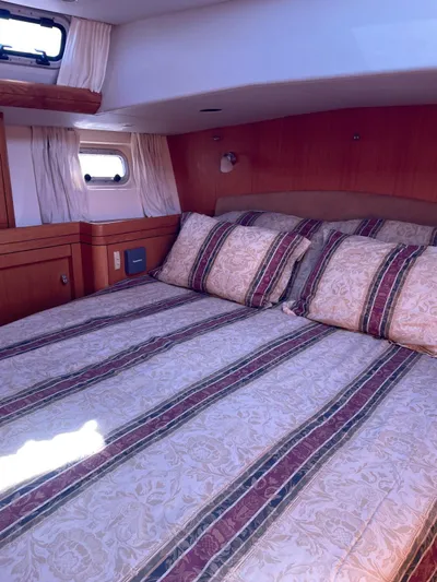 Dream Again II Yacht Photos Pics Luxurious cabin interior of 2003 Oyster 53 yacht with striped bedding.