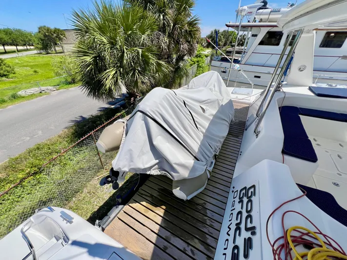 Gods Grace Yacht Photos Pics Voyage Yachts 500, 2010 model, docked with covered equipment, surrounded by lush greenery.