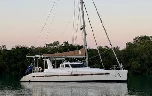 Gods Grace Yacht Photos Pics 2010 Voyage Yachts 500 catamaran sailing on calm waters at sunset.