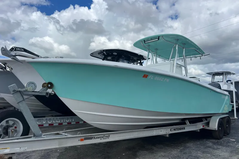  Yacht Photos Pics 2013 Contender 28 Sport boat on trailer under cloudy sky.
