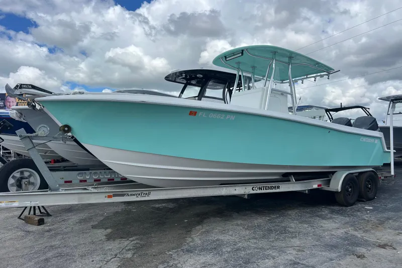  Yacht Photos Pics 2013 Contender 28 Sport boat on trailer, light blue hull, under cloudy sky.