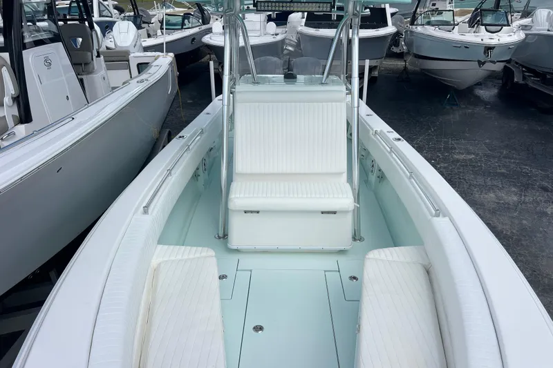  Yacht Photos Pics 2013 Contender 28 Sport boat interior with white seating, docked among other boats.