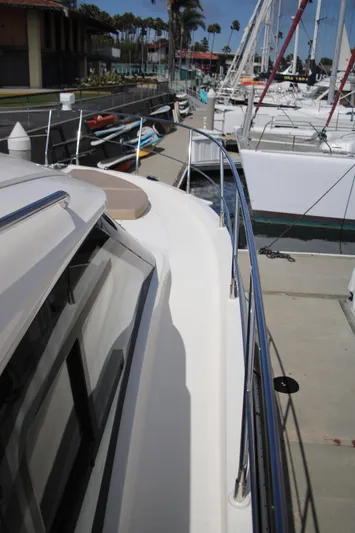 Skywalker Yacht Photos Pics Boat docked at marina with sailboats and palm trees in the background.
