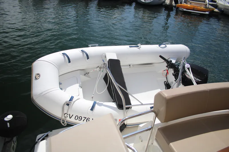 Skywalker Yacht Photos Pics Inflatable boat with outboard motor docked on calm water.