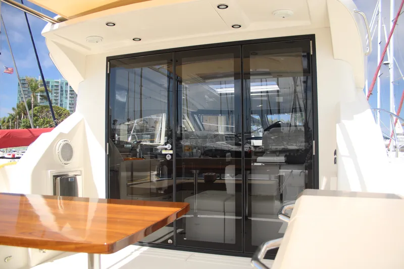 Skywalker Yacht Photos Pics Luxurious yacht interior with glass doors and wooden table, docked at a marina.