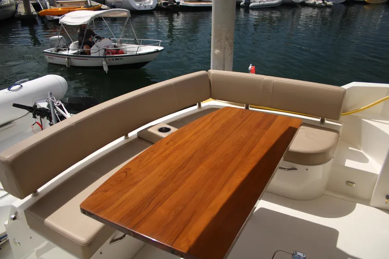 Skywalker Yacht Photos Pics Luxurious boat seating area with wooden table, docked near watercraft.