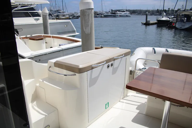Skywalker Yacht Photos Pics Luxury yacht deck with seating and table, docked at marina with boats in background.