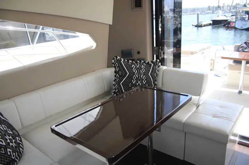 Skywalker Yacht Photos Pics Luxurious yacht interior with white seating, patterned cushions, and a polished wooden table.