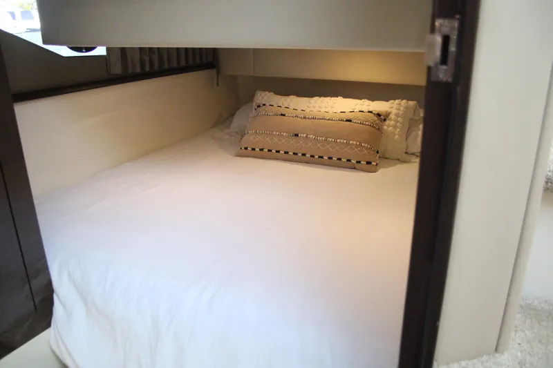 Skywalker Yacht Photos Pics Cozy cabin bed with decorative pillows in a 2018 Carver C43 Coupe.