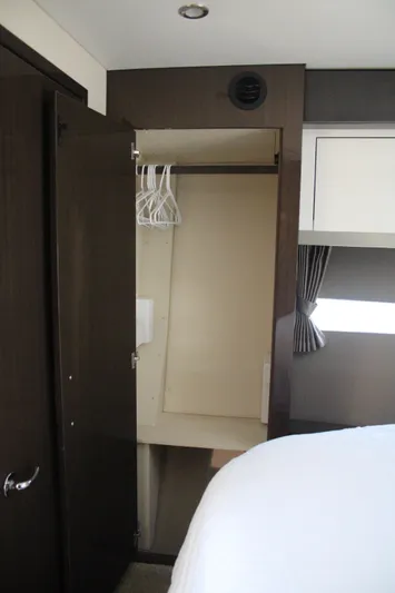 Skywalker Yacht Photos Pics Open closet in a 2018 Carver C43 Coupe interior, featuring hangers and modern design.