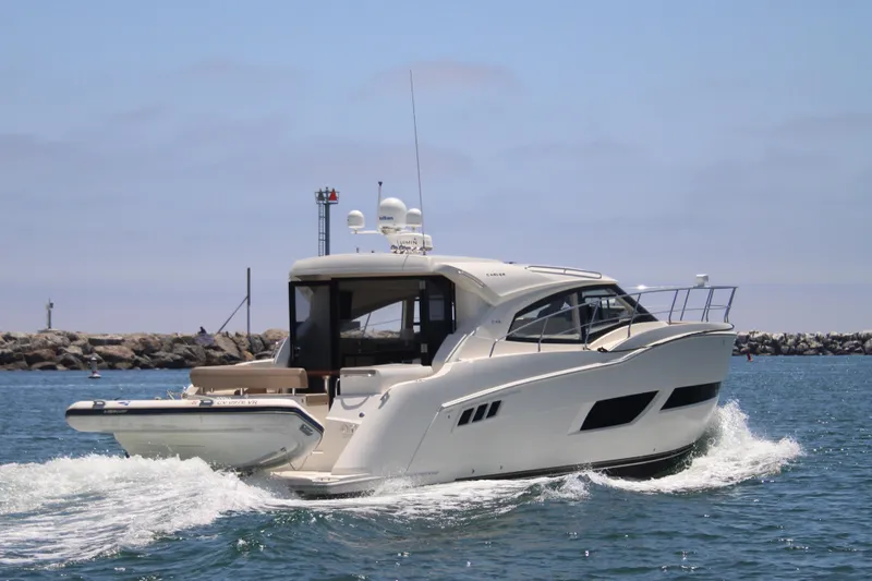 Skywalker Yacht Photos Pics 2018 Carver C43 Coupe yacht cruising on open water near rocky shoreline.