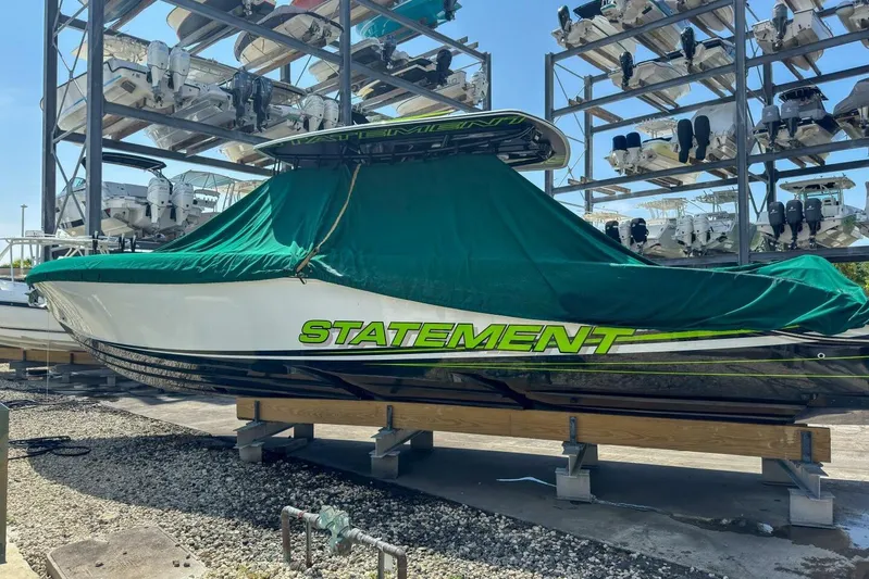  Yacht Photos Pics 2018 Statement 380 Open boat covered in green tarp, stored on a rack.