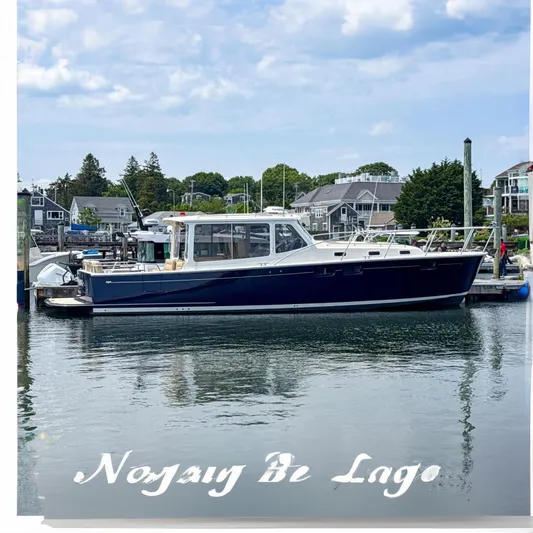 Eagle Wing Yacht Photos Pics 2017 MJM 40z Downeast boat docked in a marina, surrounded by coastal homes.