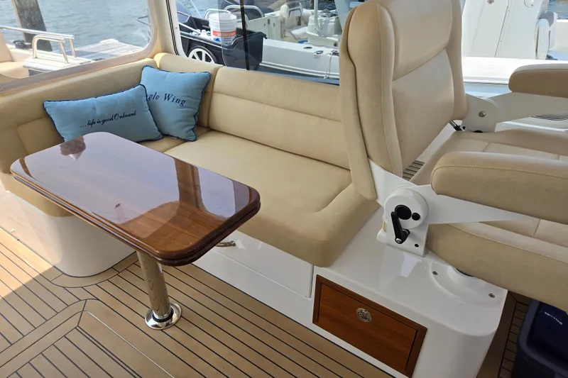 Eagle Wing Yacht Photos Pics 2017 MJM 40z Downeast yacht interior with beige seating and wooden table.