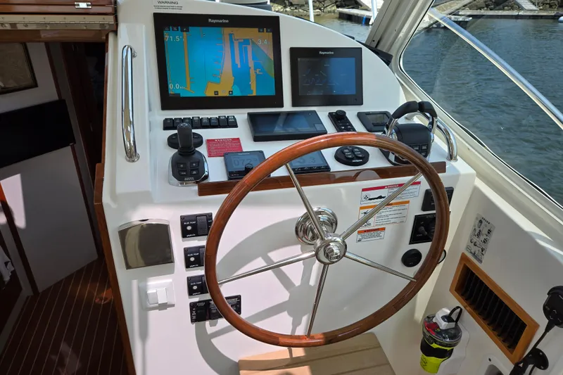 Eagle Wing Yacht Photos Pics Helm of 2017 MJM 40z Downeast boat with navigation equipment and wooden steering wheel.