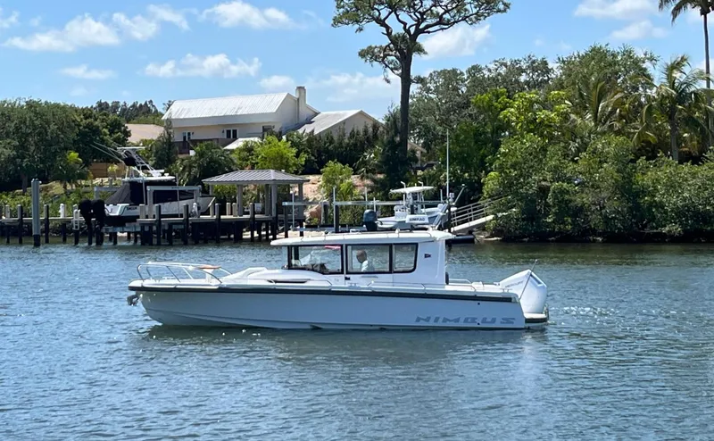 In-stock 2024 Nimbus C9 #158 Yacht Photos Pics 2024 Nimbus Commuter 9 #158 boat cruising on a sunny day near a dock.
