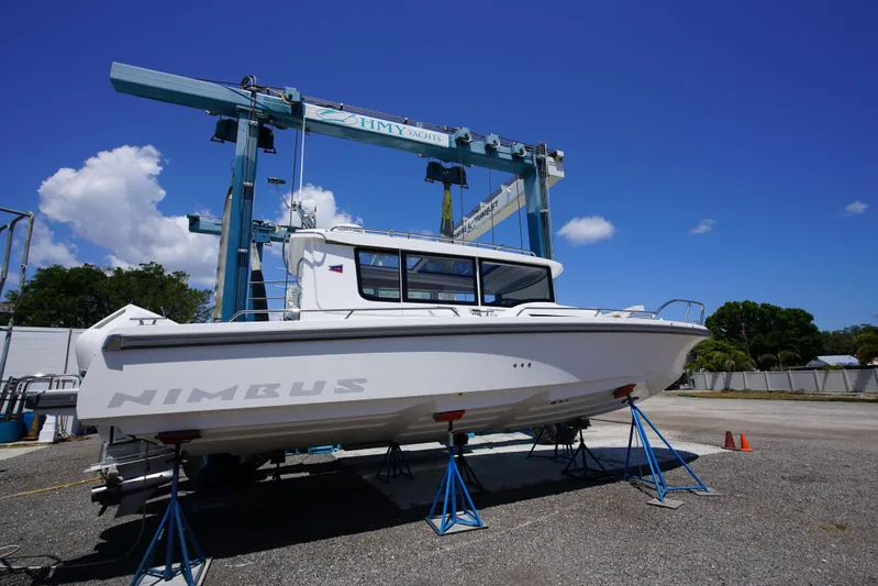 In-stock 2024 Nimbus C9 #158 Yacht Photos Pics 2024 Nimbus Commuter 9 #158 boat on stands at a marina under a clear blue sky.