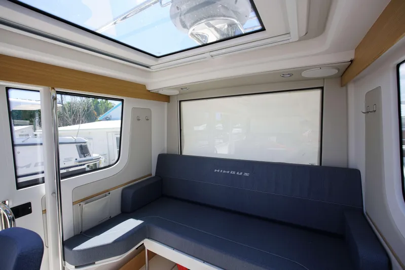 In-stock 2024 Nimbus C9 #158 Yacht Photos Pics Interior of 2024 Nimbus Commuter 9 #158 with blue seating and large windows.