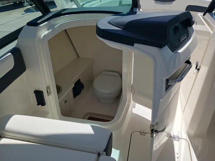 257-155 Yacht Photos Pics 2025 Robalo R257 Dual Console boat interior with compact marine toilet.