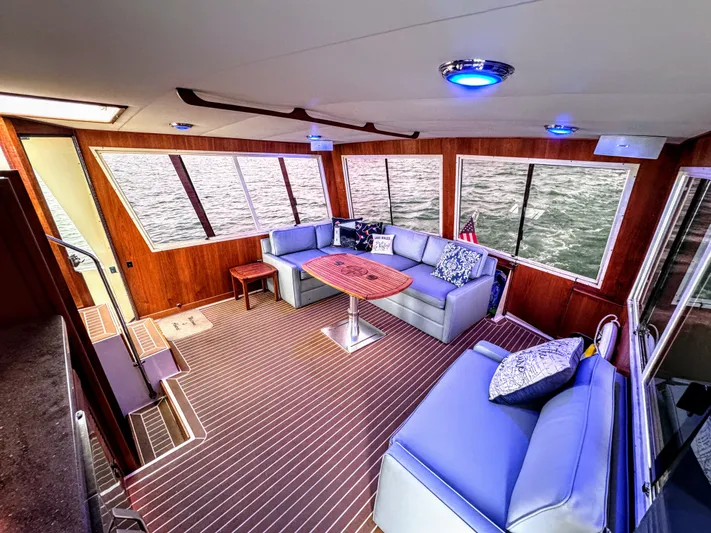 Sunshine State Yacht Photos Pics Interior of 1987 Viking 48 Motoryacht with blue sofas and wooden flooring.