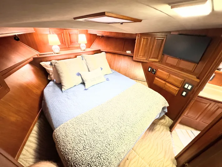 Sunshine State Yacht Photos Pics Interior of 1987 Viking 48 Motoryacht, cozy bedroom with wooden furnishings.