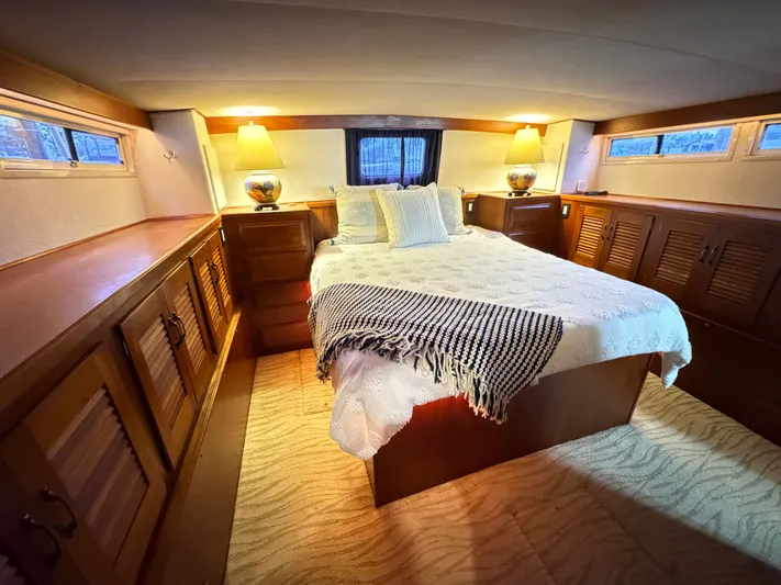 Sunshine State Yacht Photos Pics Bedroom in 1987 Viking 48 Motoryacht with cozy bed and wooden furnishings.