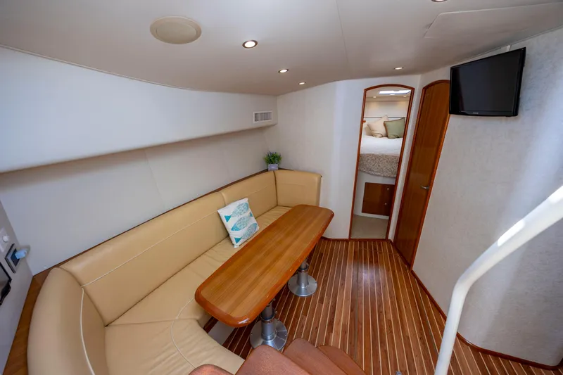 Life Is Good Yacht Photos Pics 2013 Viking 42 yacht interior with dining area, wooden flooring, and cozy seating.